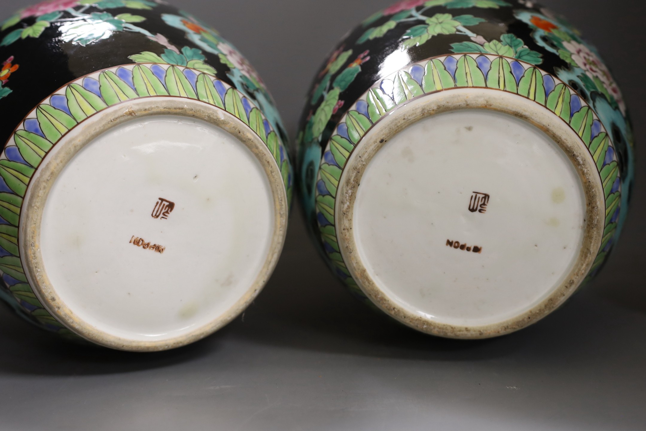 A pair of Japanese famille noire jars and covers 27cm